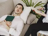 Man resting on a couch while a therapist takes notes during a ketamine therapy session